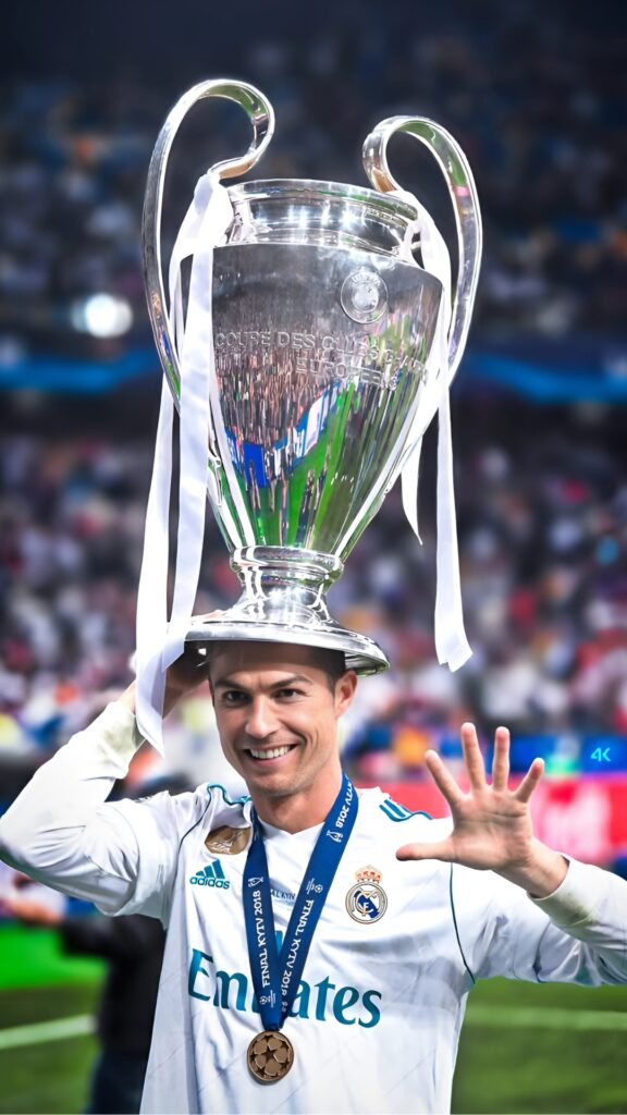 Cristiano Ronaldo wearing Real Madrid kit holding the UEFA Champions League trophy on his head, showing five fingers – 4K celebration wallpaper.