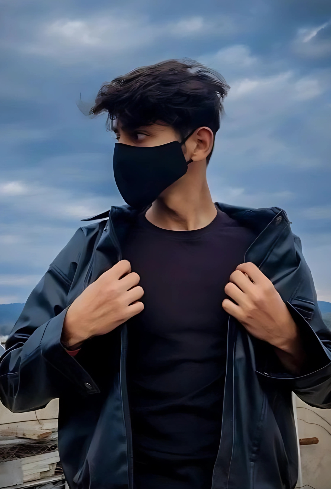 Stylish boy wearing a black mask and leather jacket posing outdoors under cloudy sky – Instagram DP
