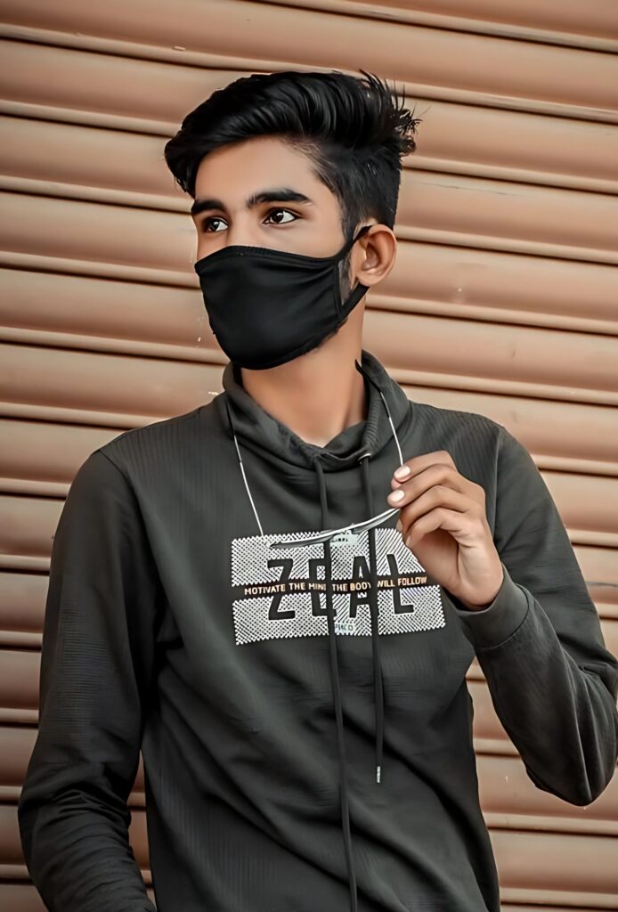 Stylish young boy in black face mask posing confidently in front of brown shutter background