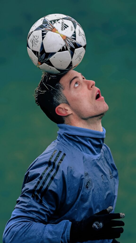 Cristiano Ronaldo balancing a football on his head during training in Real Madrid kit – 4K wallpaper.