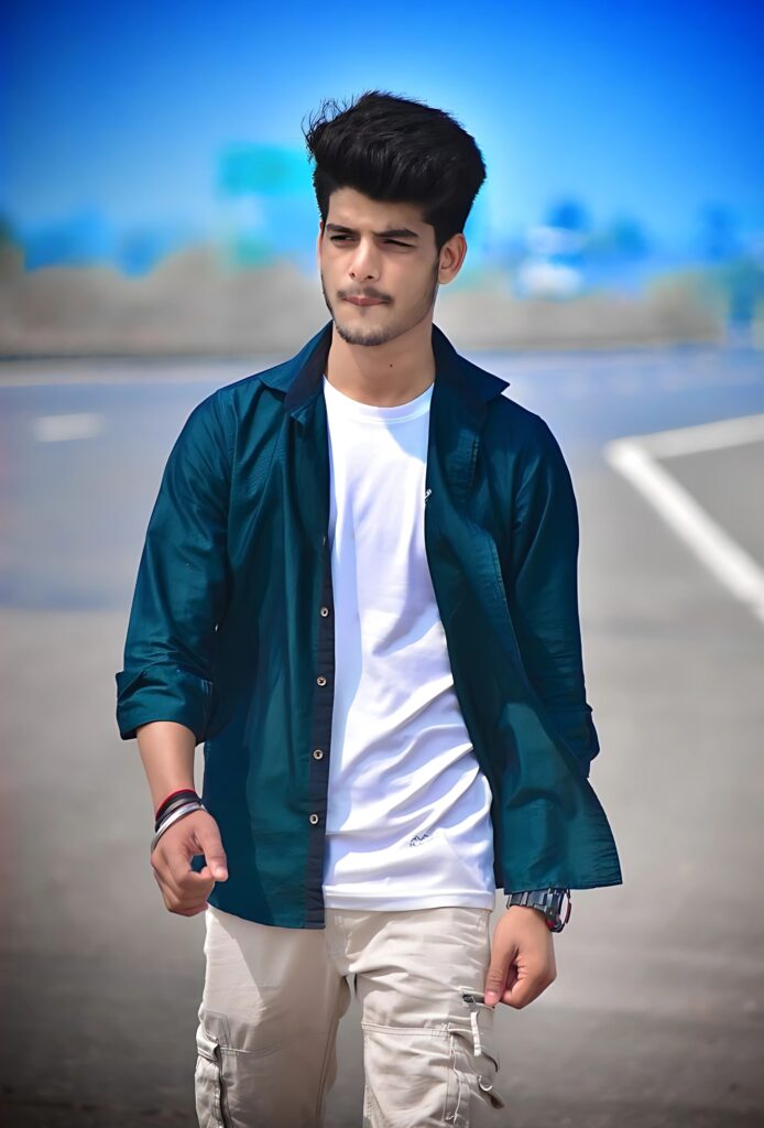 Handsome young man walking on the road in a teal shirt and white tee, looking confidently ahead