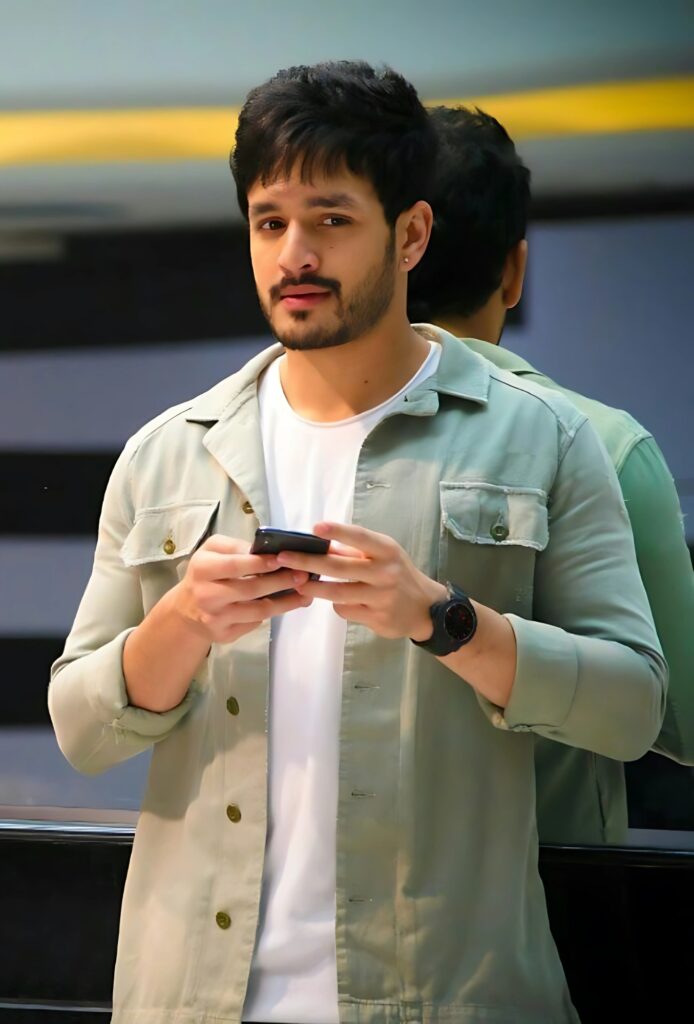 Stylish single boy wearing green jacket over white T-shirt, holding phone with serious expression, ideal for mobile DP or wallpaper.