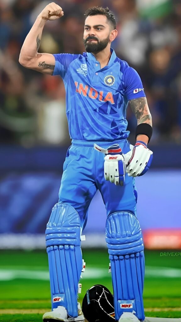 Virat Kohli in Indian cricket team jersey celebrating on the field with a raised fist – HD wallpaper.