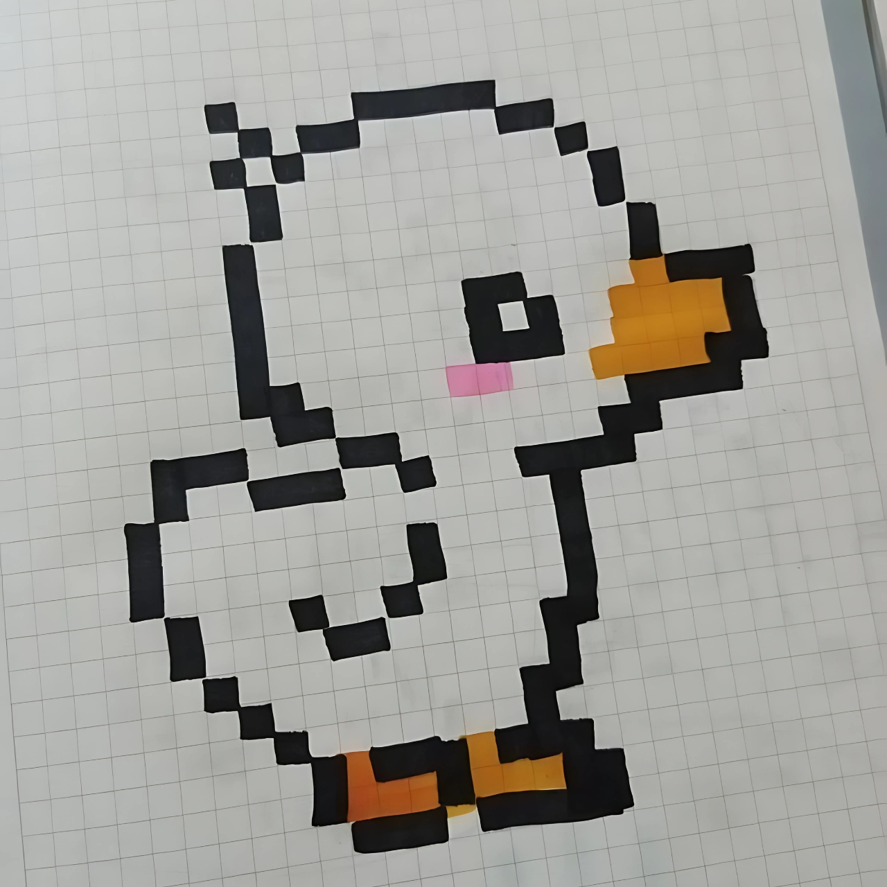 Cute pixel art duck drawn on graph paper with black outline, orange beak and feet, and pink cheek detail.