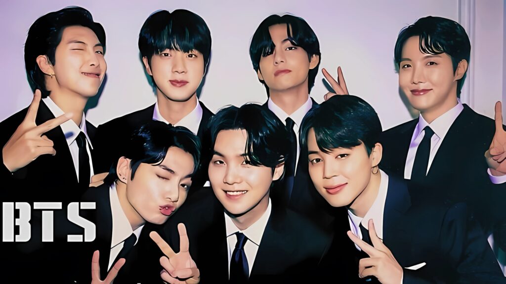 BTS members posing in suits with playful expressions and peace signs in a group photo for laptop wallpaper.