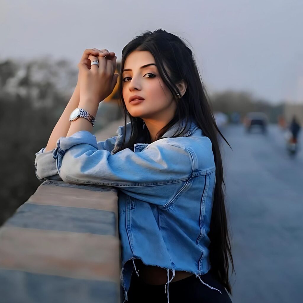 Stylish girl in denim jacket posing confidently on a bridge at sunset – fashionable WhatsApp DP for girls with a cool and elegant vibe.