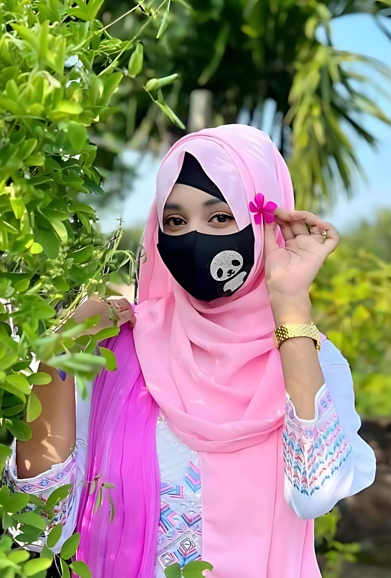 Stylish hijab girl wearing a pink scarf and panda mask holding a flower – perfect aesthetic profile picture.