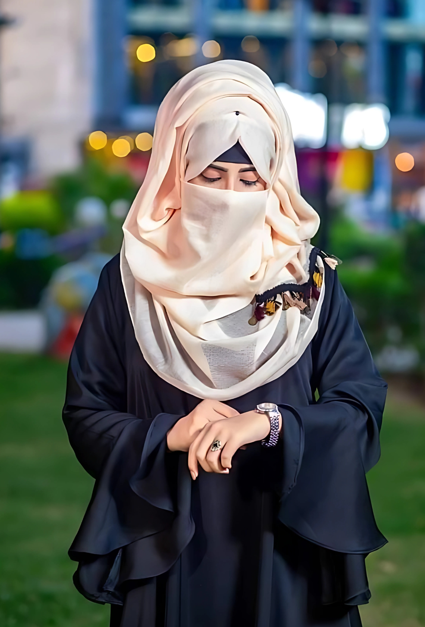 Stylish hijab girl in black abaya and cream scarf posing gracefully in a modern urban park – perfect for Muslim girl DP and hijab fashion inspiration.