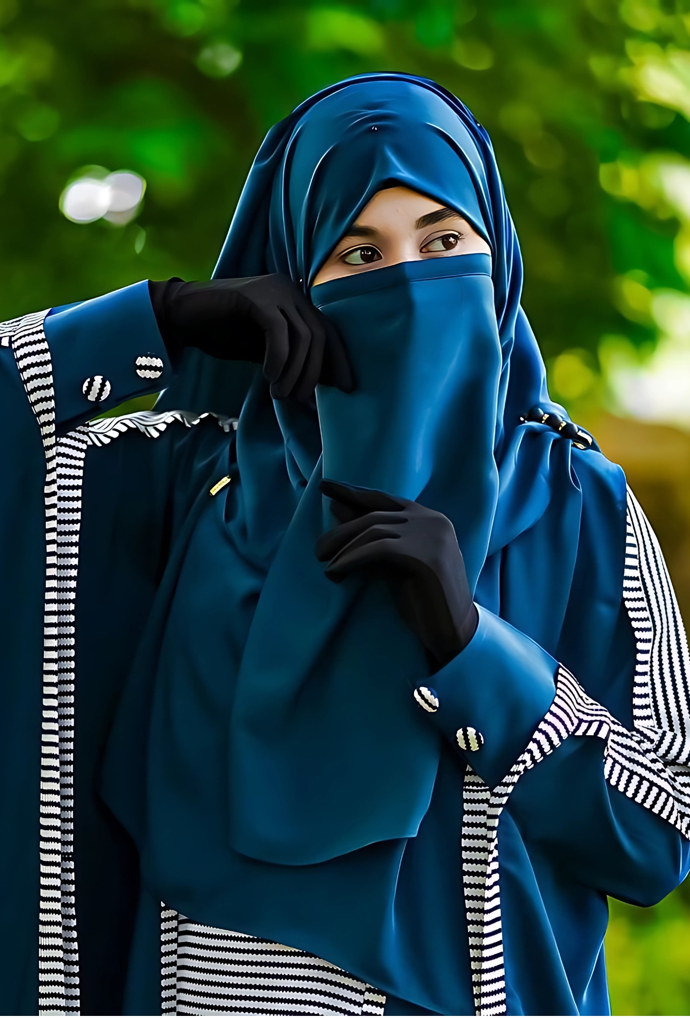 Elegant Muslim girl in a teal hijab and abaya with black gloves, posing gracefully with a modest face cover against a vibrant green background – ideal hijab profile picture for girls.