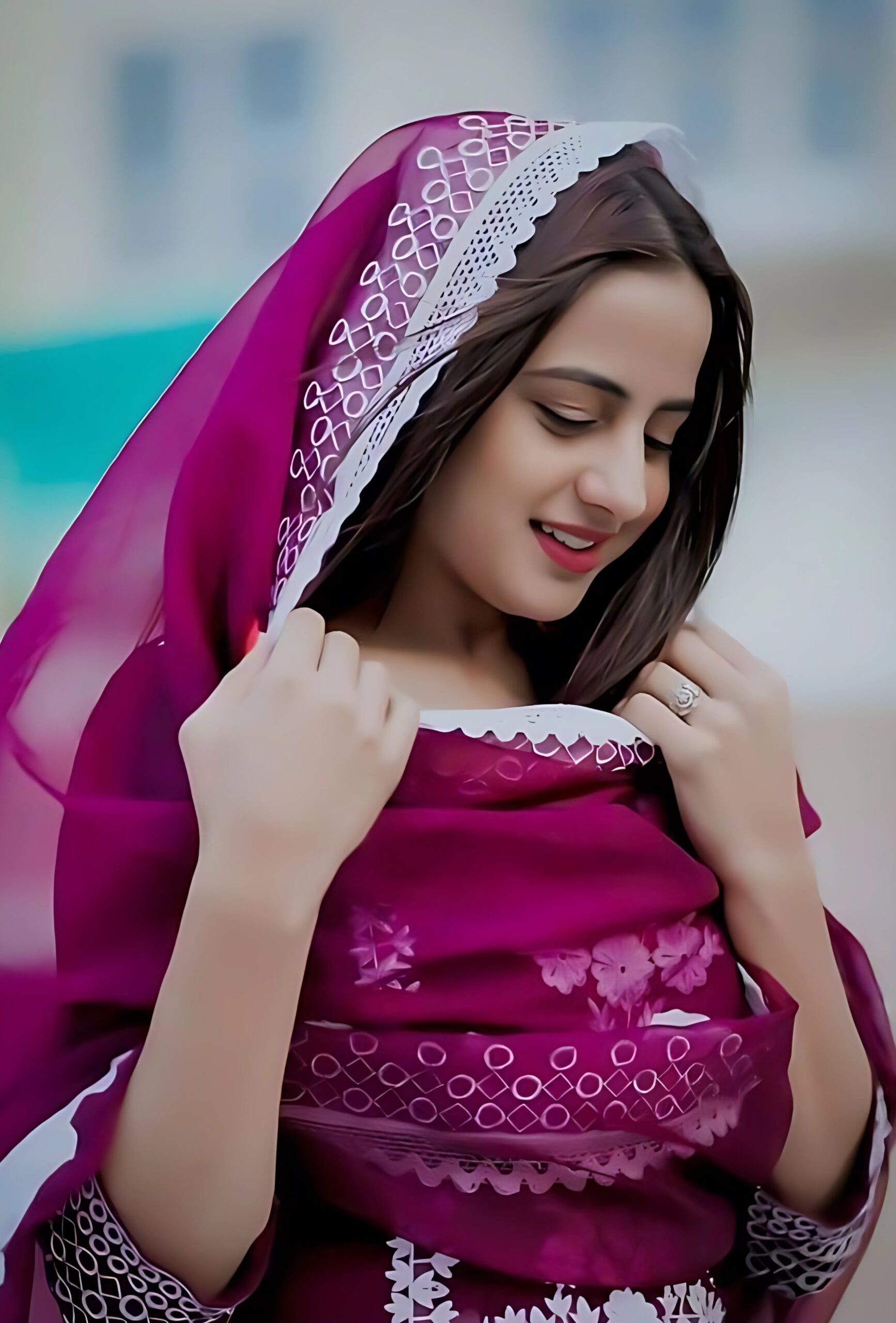 Muslim girl in maroon traditional dress with embroidered dupatta, smiling and looking down in a graceful pose for profile picture