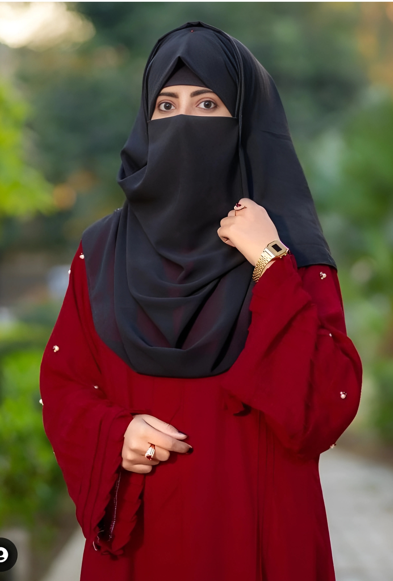 Hijab girl standing in a garden wearing a red dress and black niqab – beautiful Muslim girl profile picture HD.
