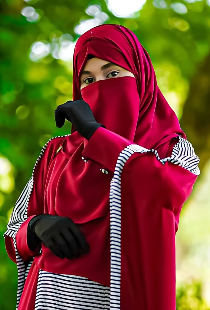 Stunning hijab girl in a red abaya and black gloves, posing modestly in nature – perfect 4K HD wallpaper for Islamic and hijab-themed profiles.